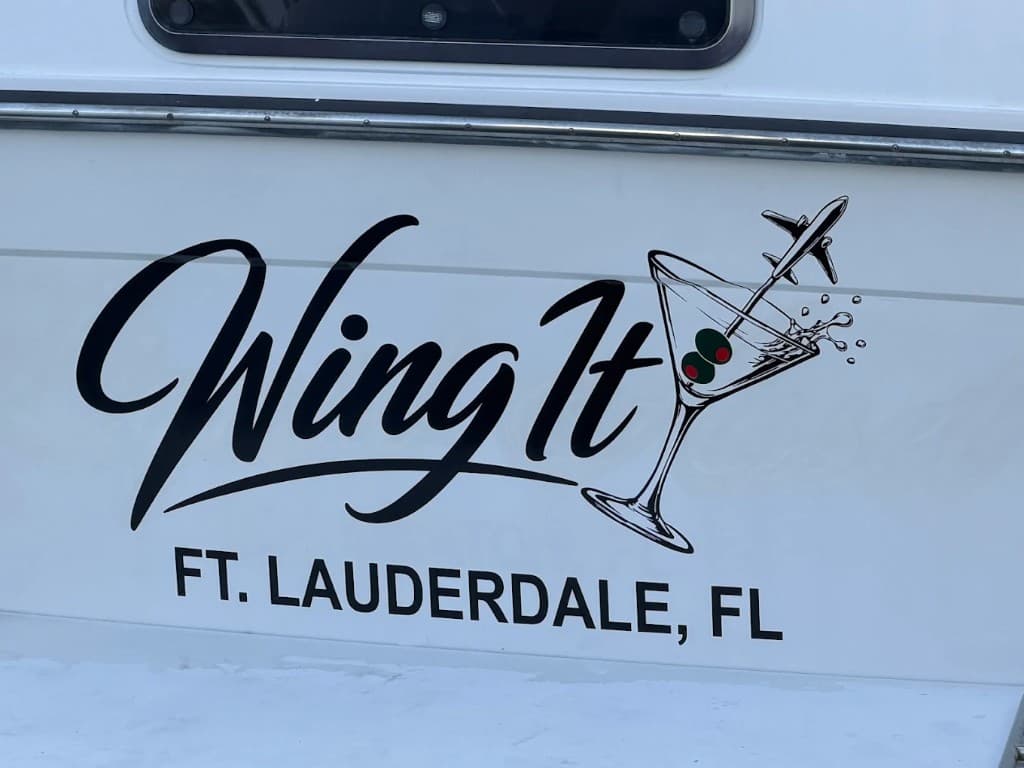 Gold Champagne Cher script lettering and Wilmington port on a white yacht transom